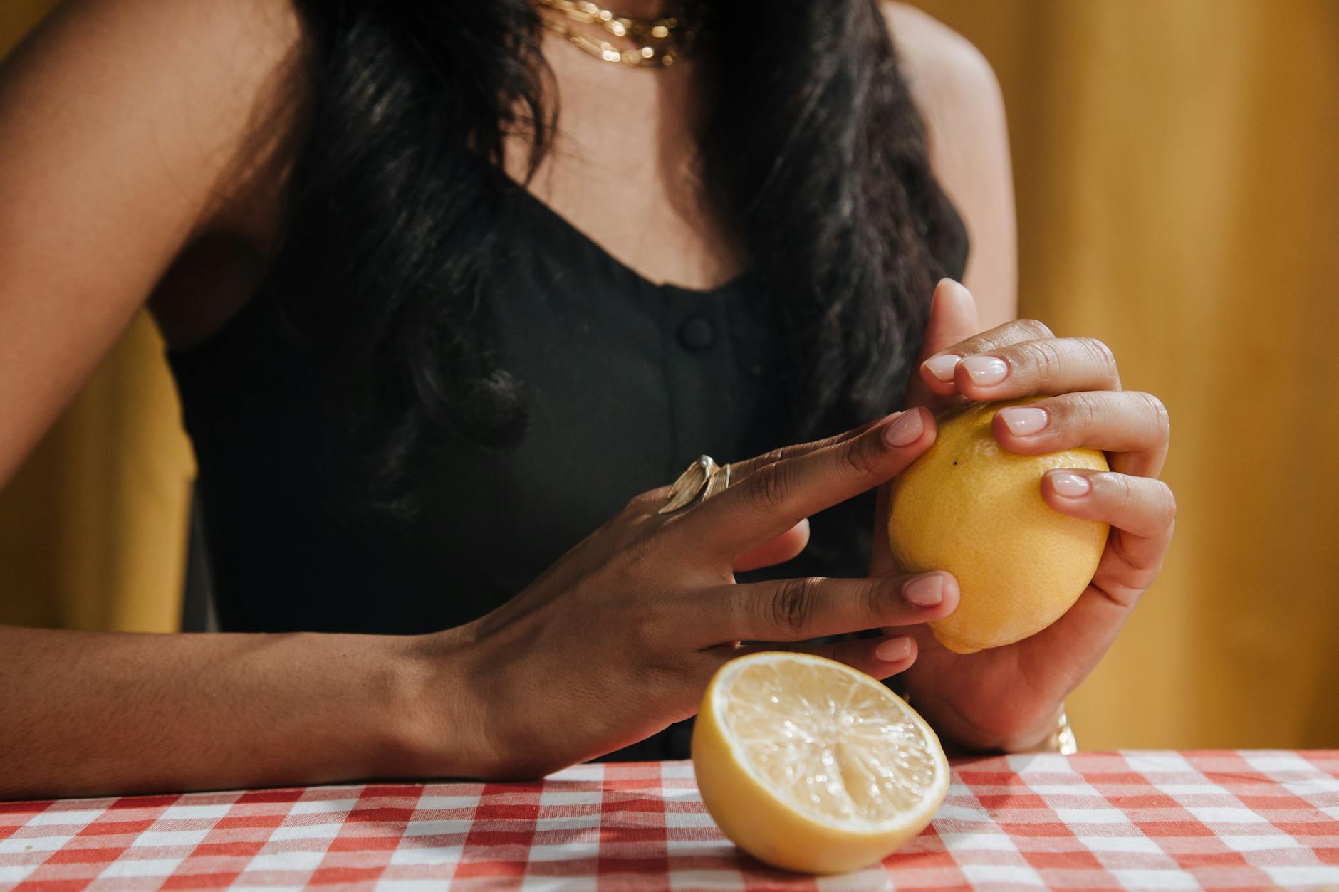 A hand holding an orange vibrator against a minimalistic purple backdrop, showcasing modern sensuality