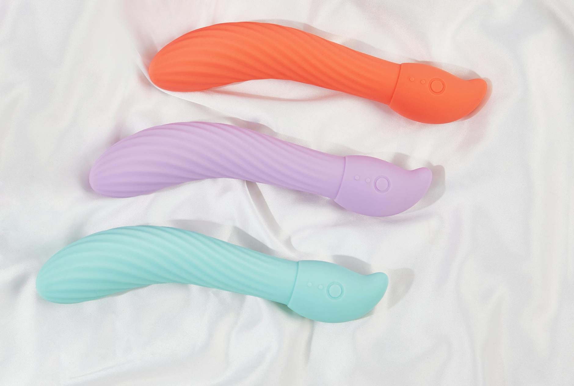 Woman holding two vibrators with contemplative expression during pleasure recovery journey