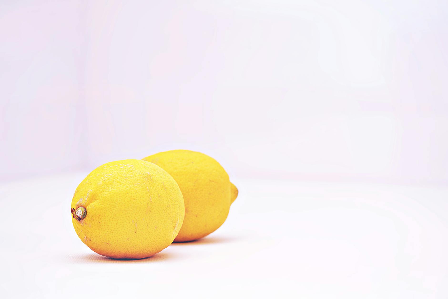 Two vibrant lemons on a white background representing fresh sensation and renewal