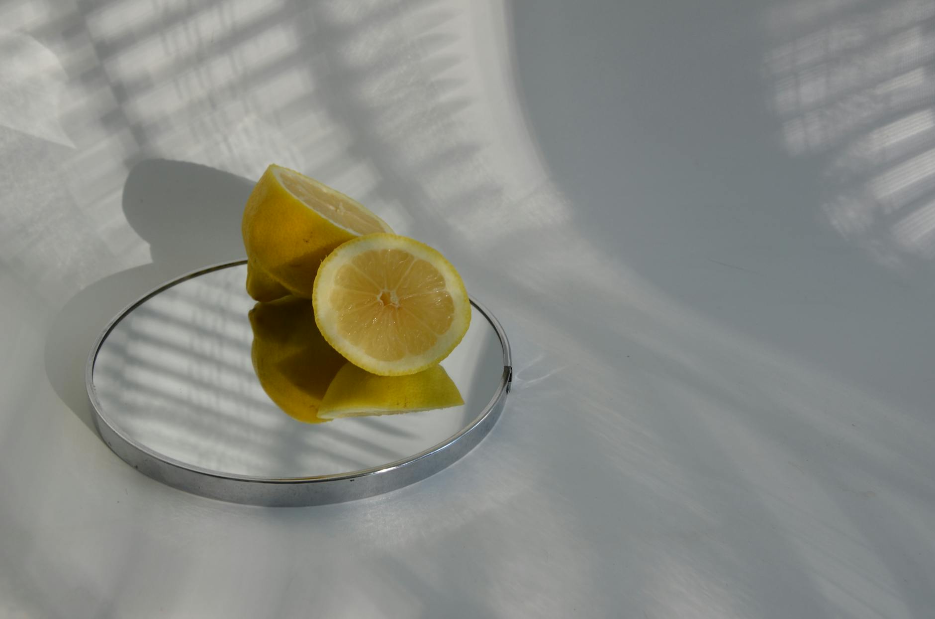 Sliced lemons on a mirror with soft shadows, symbolizing fresh approaches to clitoral pleasure