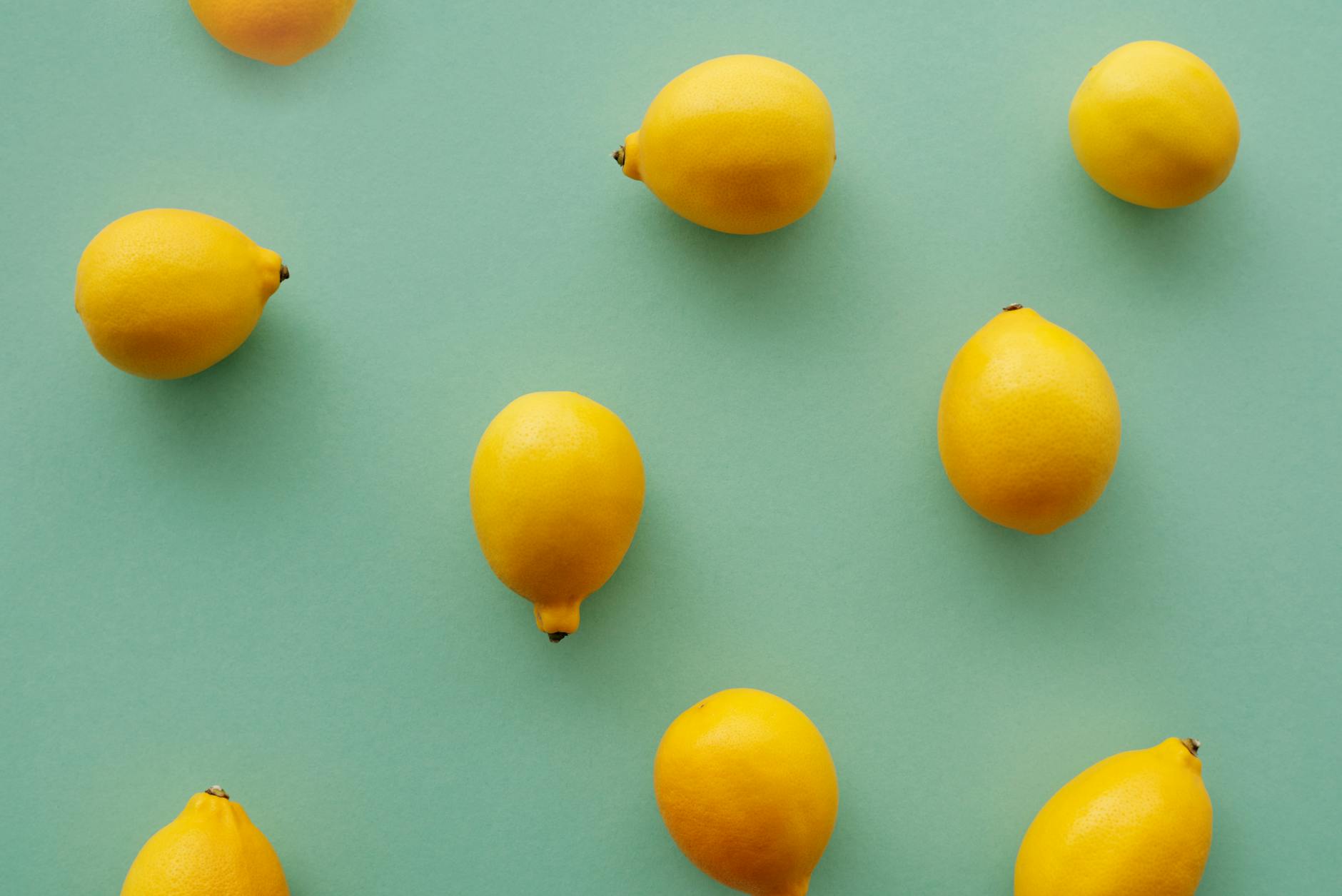 Bright yellow lemons on a pastel green background, representing quick and efficient pleasure solutions