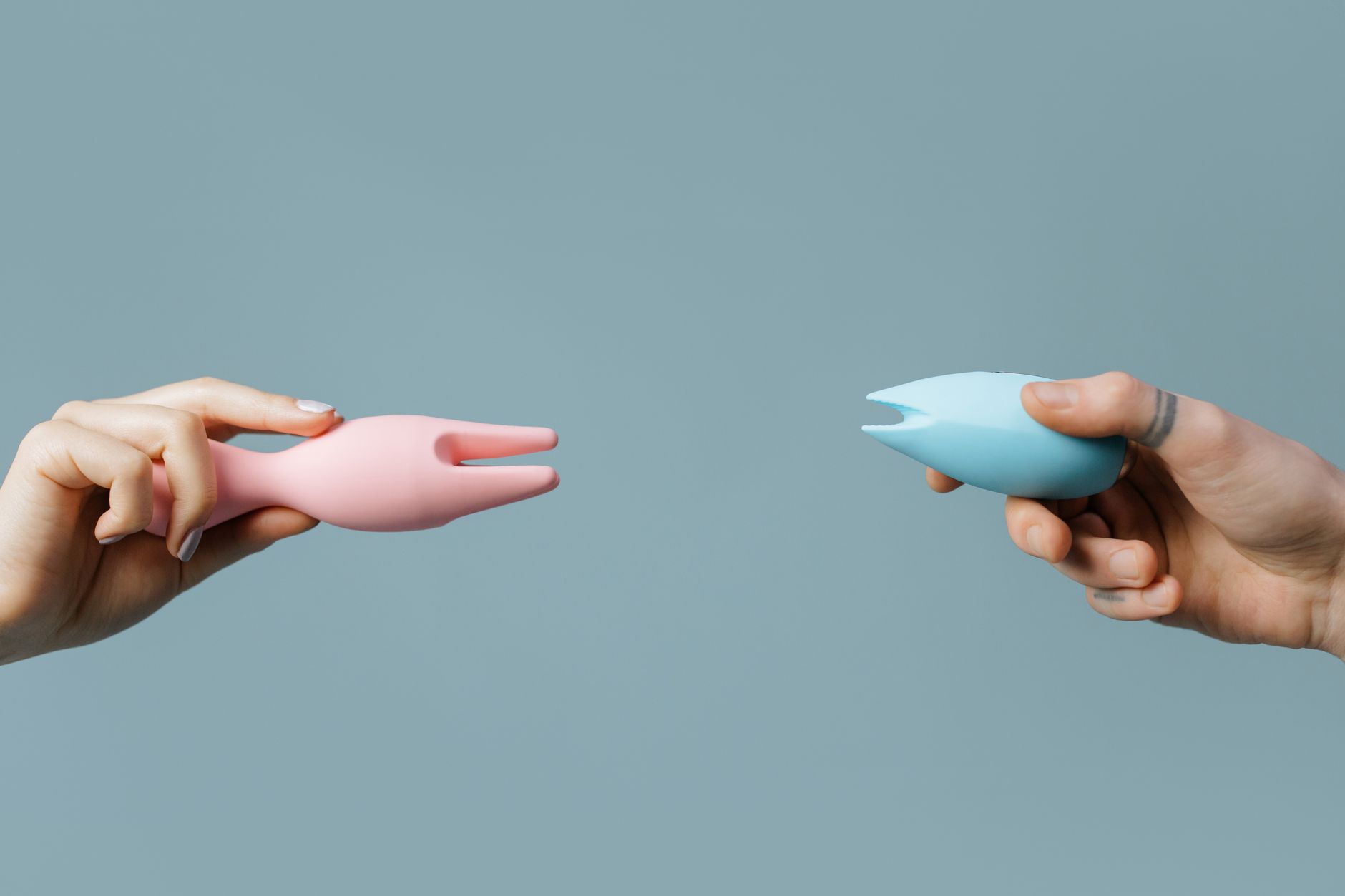 A hand holding an orange vibrator against a minimalistic purple backdrop, showcasing personal empowerment and modern sensuality.