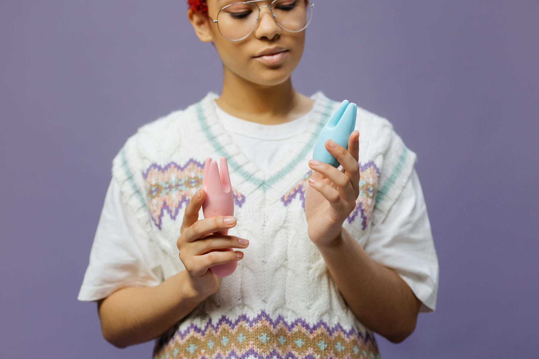 Woman holding colorful silicone vibrators, representing exploration during unpredictable arousal patterns.