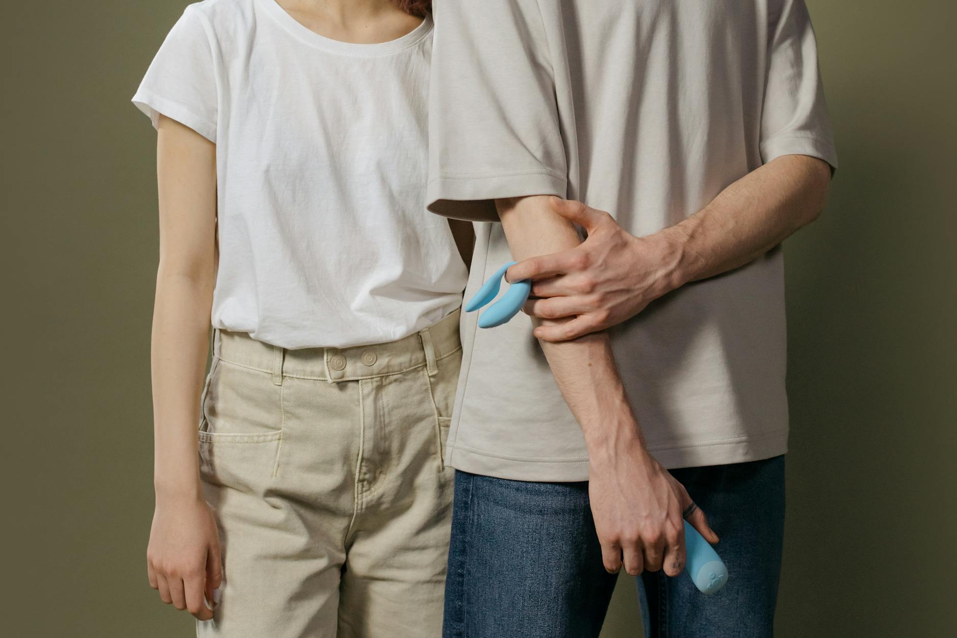 Hand holding a lemon-colored vibrator against a minimalistic purple backdrop