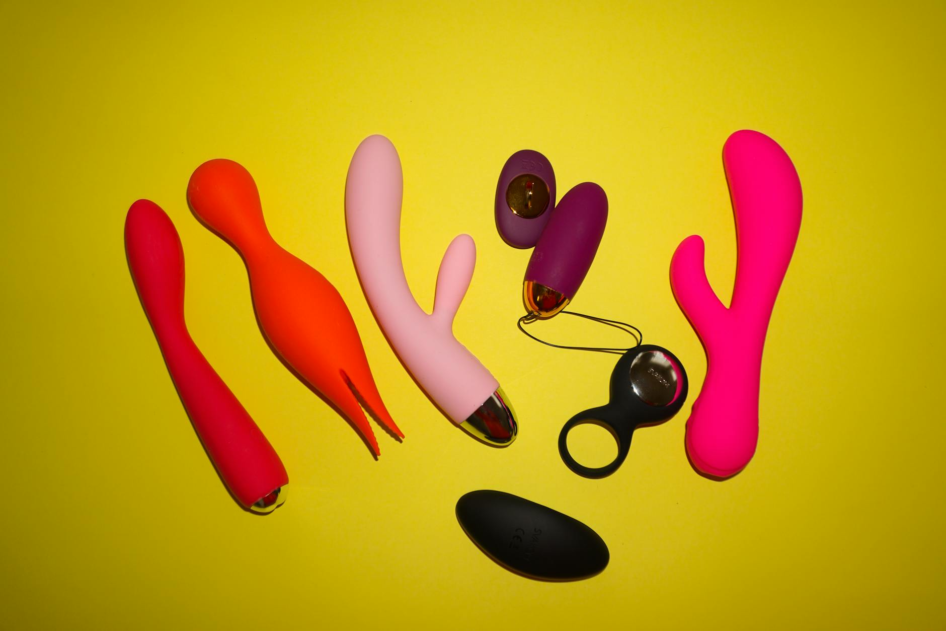 Collection of colorful lemon adult toys and vibrators displayed against a bright yellow background