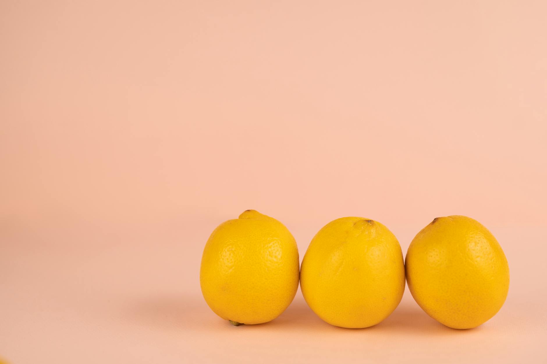 Frische gelbe Zitronen auf pastellfarbenem Hintergrund, symbolisierend Lebendigkeit und Verjüngung