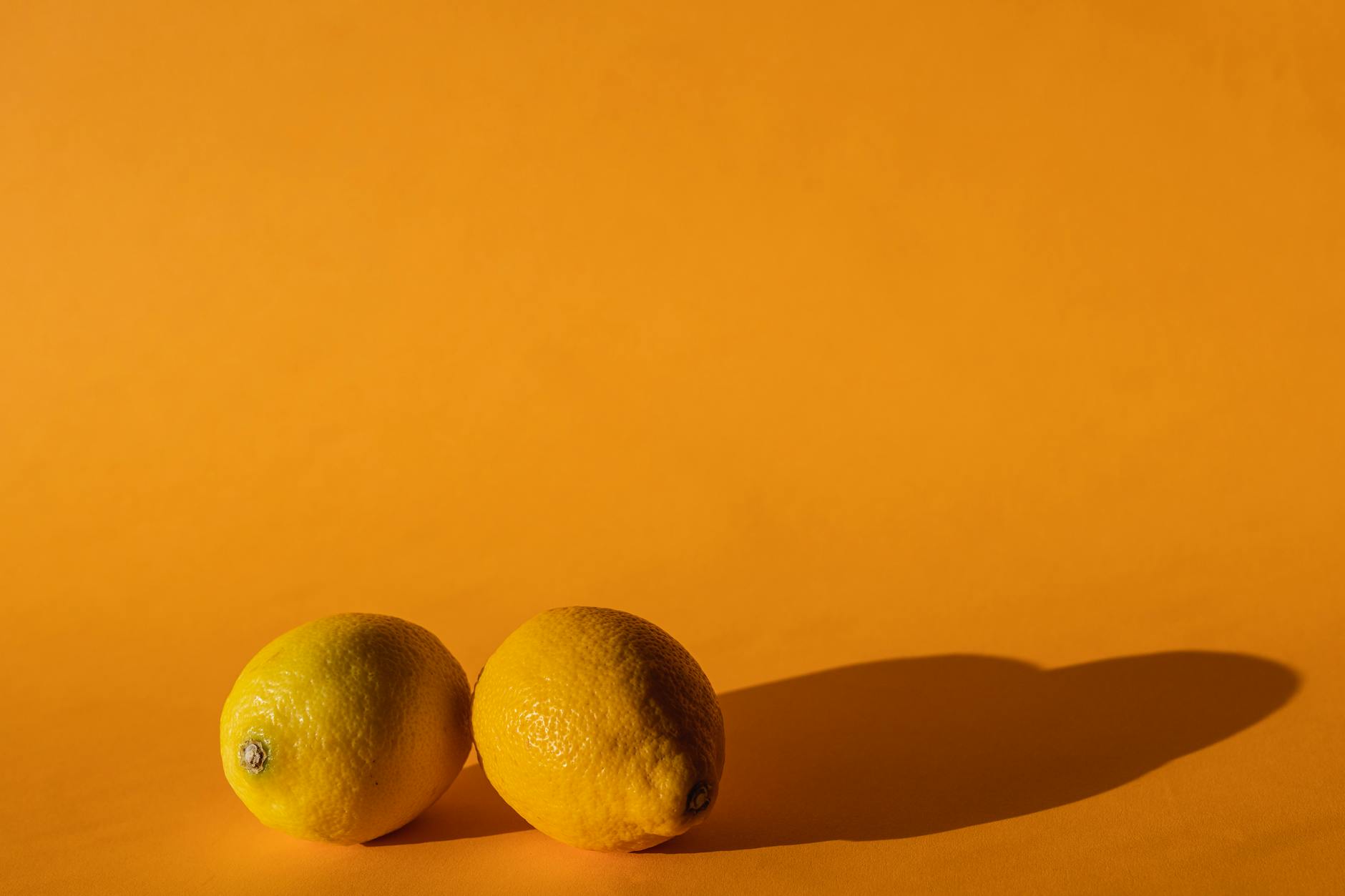Fresh lemons arranged on a yellow background, symbolizing the varied and natural rhythms of hormonal cycles